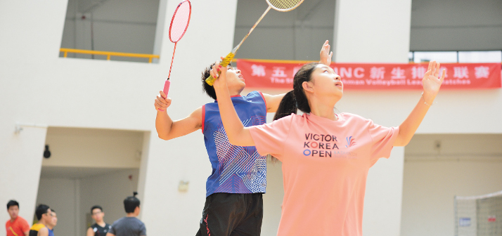 Two students playing badminton