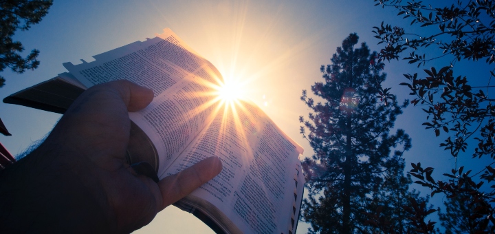 Holding a the bible outside with the sun shining
