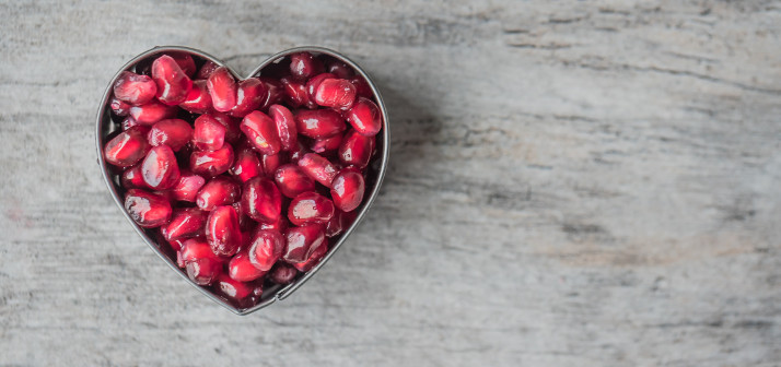 Heart shaped bowl of pomegranate seeds