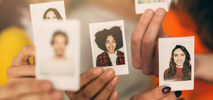 Close up of people holding polaroid images of themselves in their hands