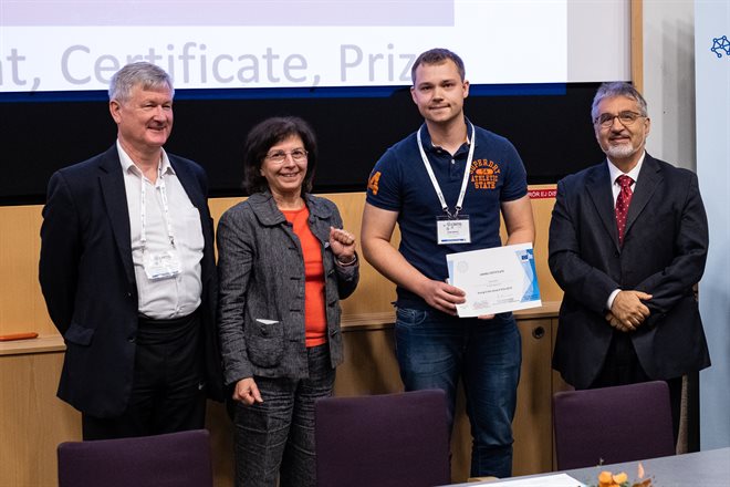 PhD student collecting certificate for award at conference