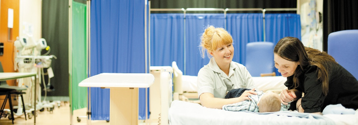 Female midwifery student assessing a new born baby, Nursery and Midwifery Unit, QMC 714x249