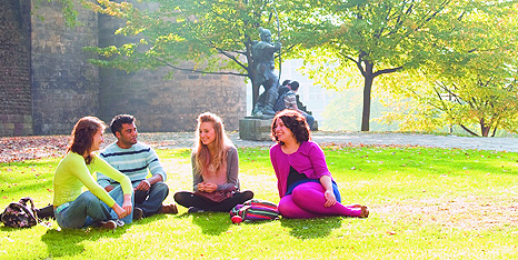 Four students sat on grass at Highfields Park.