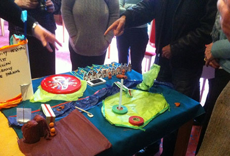 A table with crafts in progress and people interacting.