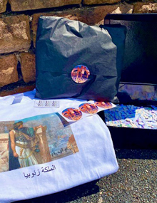 A printed t-shirt, branded wrapping paper and case of stickers advertising Palmyra