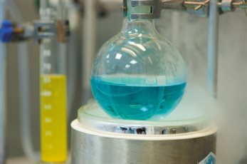 Science experiment containing blue liquid in a glass beaker