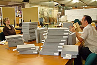 Members of staff repackaging books in the reading room at Hallward Library