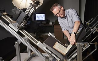Mark Bentley photographing a book  using the preservation book cradle