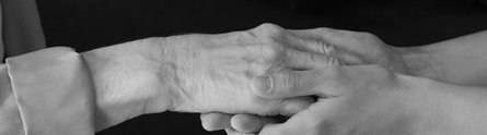 Hands of a young woman holding an elderly lady's hand