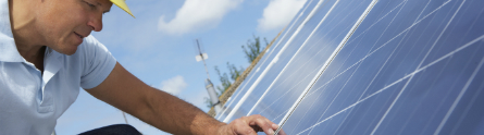 Worker installing solar panels 445 x 124