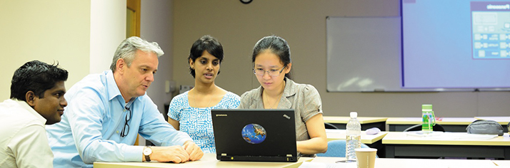 Postgraduate students at a laptop, Kuala Lumpur Teaching Centre