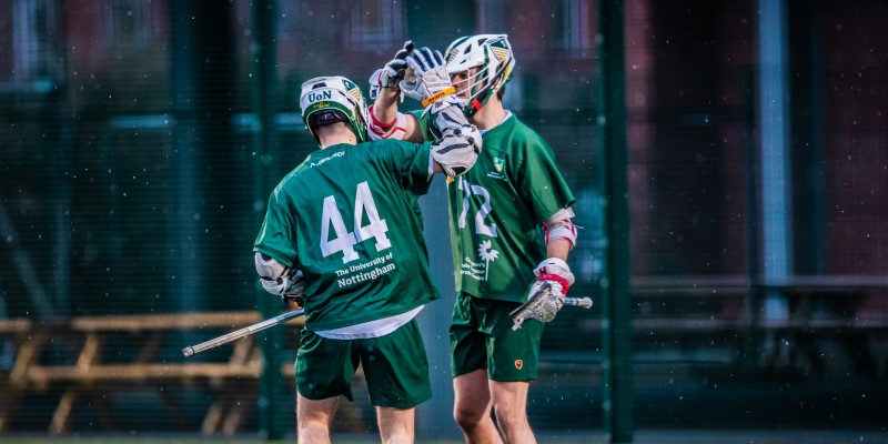 Men's Lacrosse players high five in snowy weather
