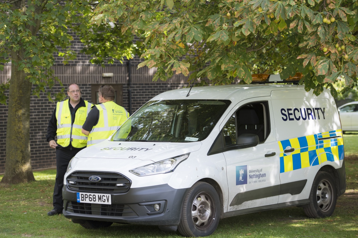 Security officers with a security van on campus