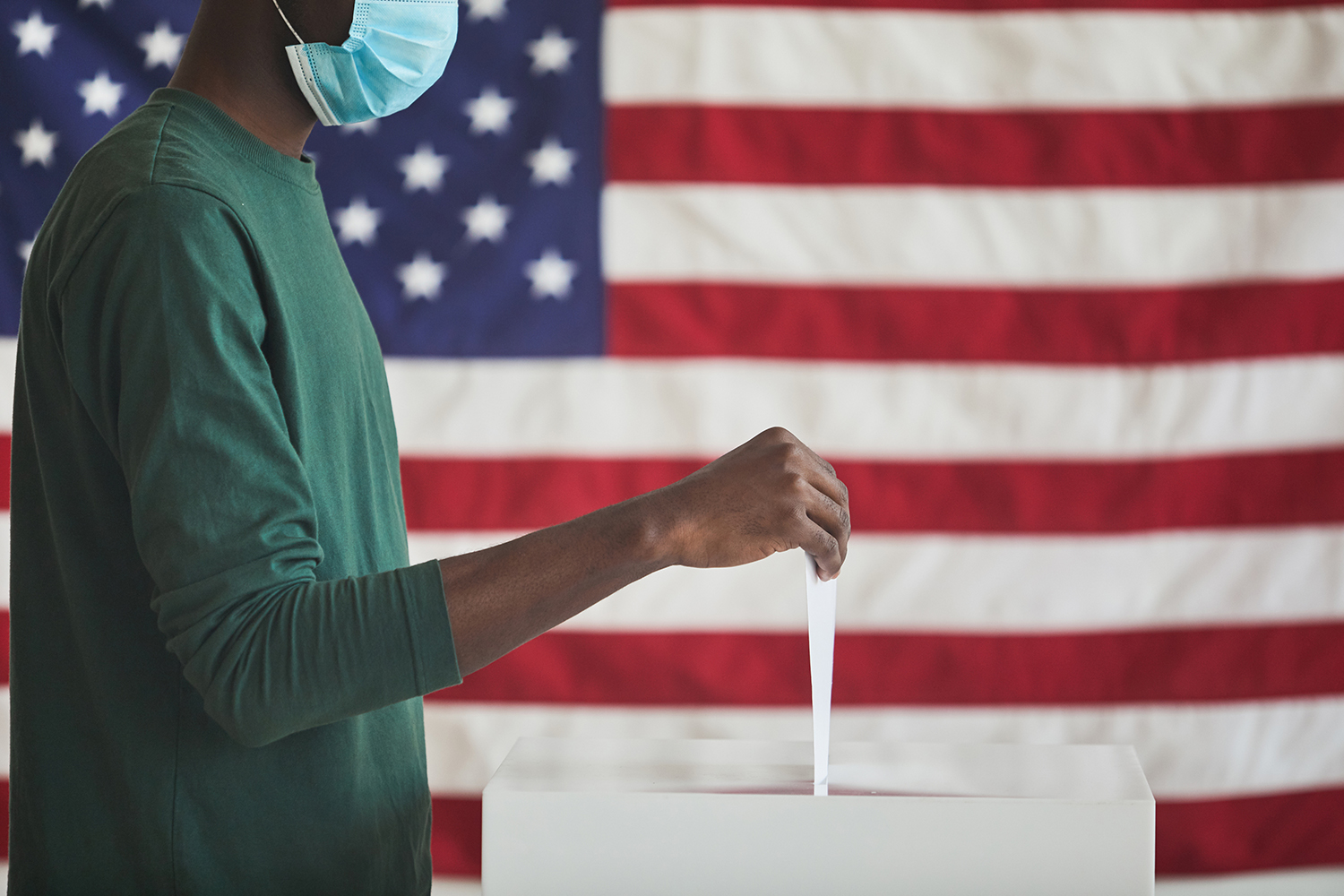 Person voting in front of the American flag