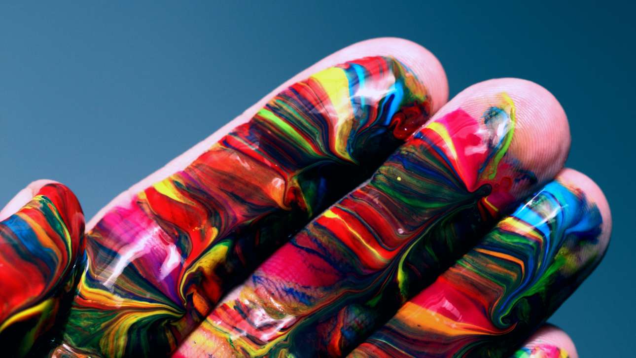 A human hand painted with colourful paint