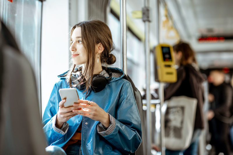 Young woman on a bus using her smartphone