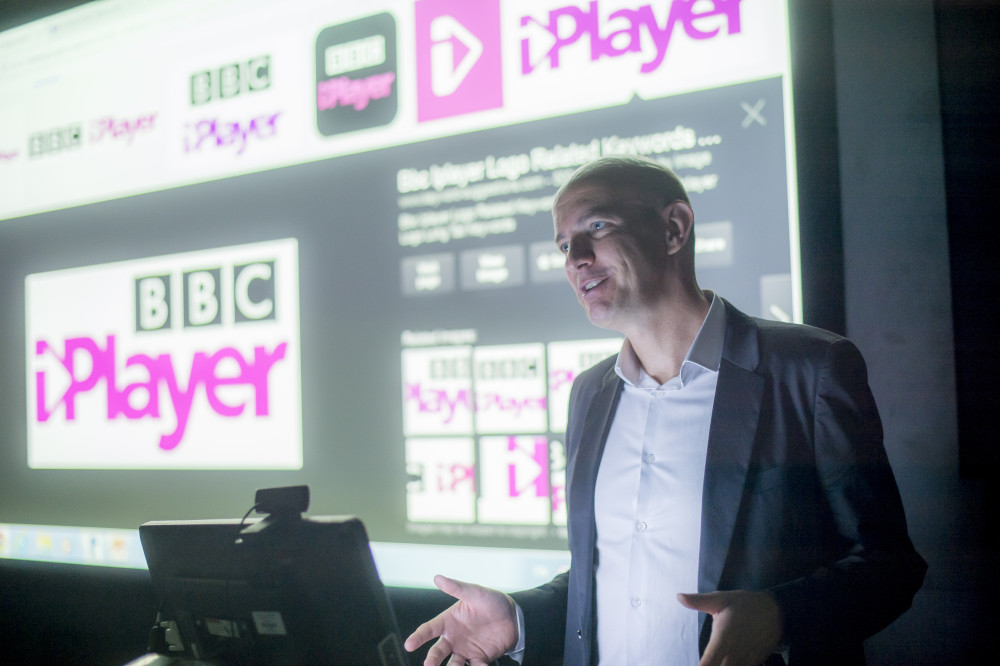 Lecturer presenting beside screen showing BBC iPlayer information
