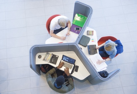 Ariel view of three students working in study booth table