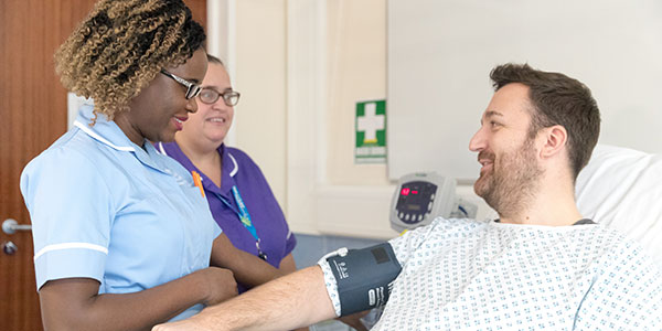 A man having his blood pressure taken by a nurse