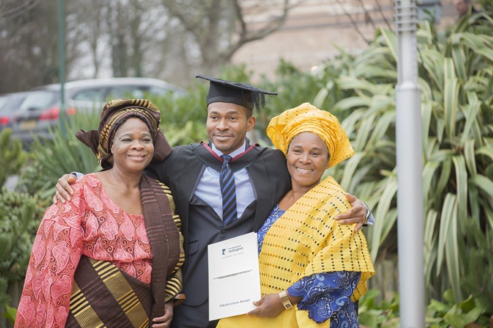 A student standing with family on graduation day