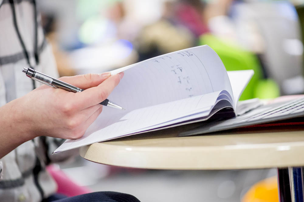 Close up of student working in a notebook