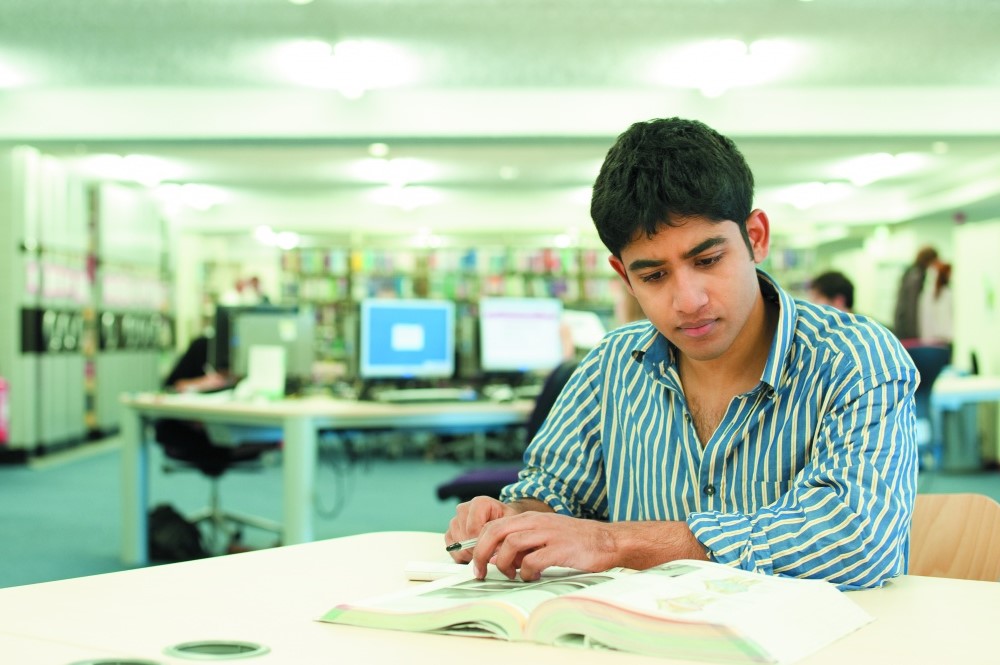 Male student studying in a library