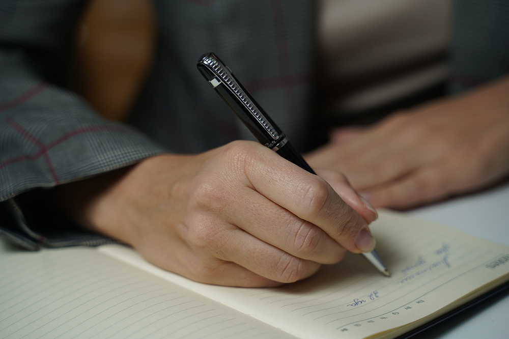 A person writing notes in a notebook
