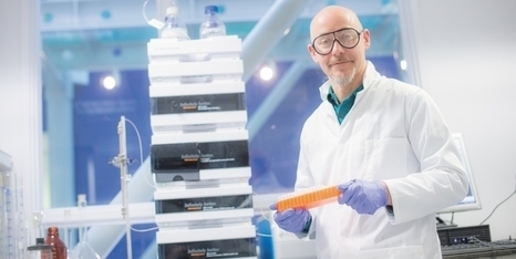 Prof Cameron Alexander holding research samples