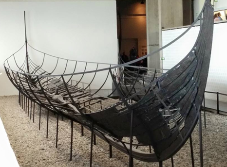 Photograph of a partially reconstructed ancient ship in a museum display