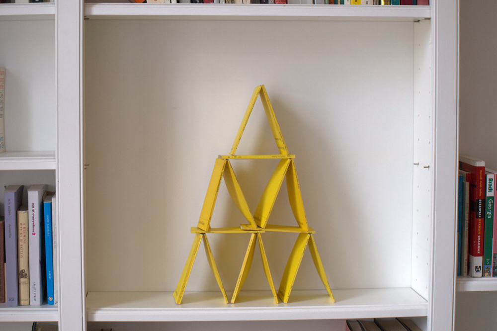 Pyramid of yellow pamphlets in bookshelf