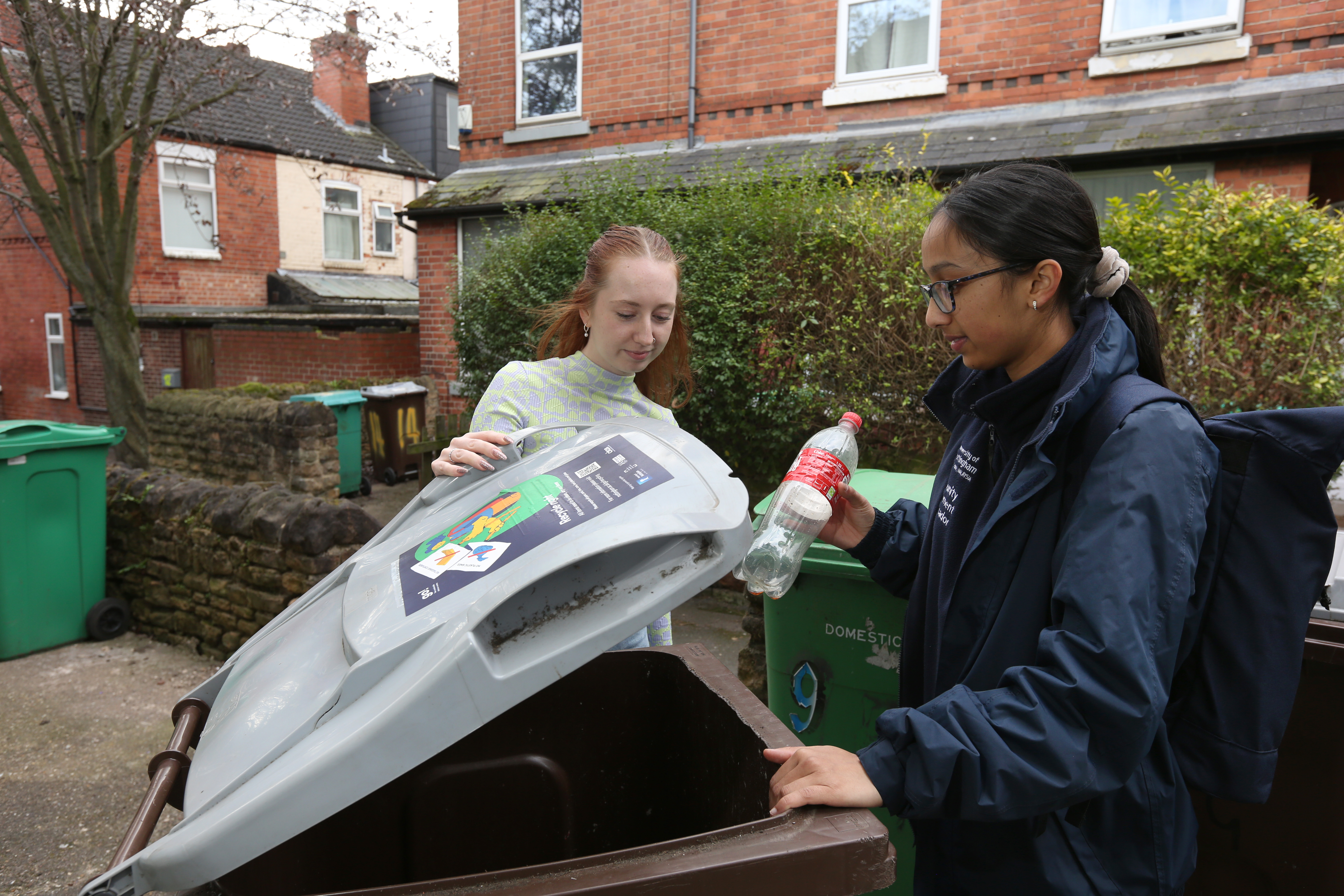 Community Engagement Ambassador helps a student recycle correctly