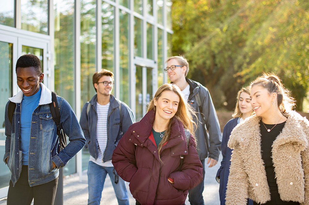 Students walking outside in a group smiling