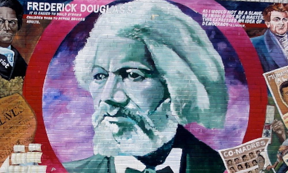 Photo of the Frederick Douglas Mural showing a black and white picture of Douglas in the centre surrounded by quotes and smaller images