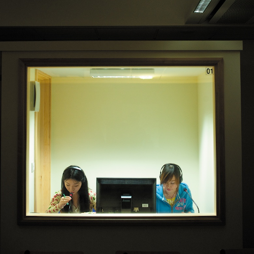 Two students in sealed translation booth