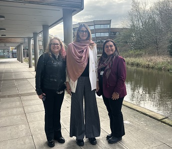 Helen Kennedy, Maria Pia and Marina Novelli stood by the lake on Jubilee Campus, The Djanogly Learning Resource Centre is in the background.