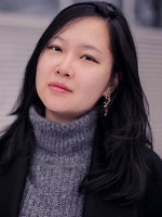 Head and shoulders photo of Dr Carol Zhang. Carol has long dark hair and is wearing a grey jumper and black jacket