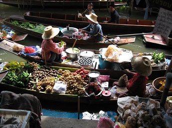 An aerial view of a Thailand floating market, showing boats with colourful produce on them.
