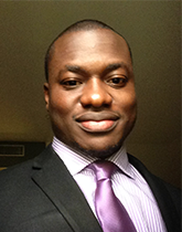 Photo of Emmanuel Adegbite. Emmanuel is wearing a black jacket with a white shirt and purple silk tie.