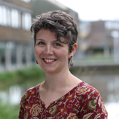 Head and shoulders photo of Anne Touboulic. Jubilee Campus lake and buildings are in the background.