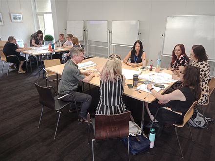 Small-group discussion in progress. The Cultural Participation Staff Team is shown at the front, and the Libraries Staff Team, in the background