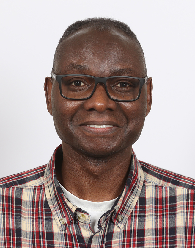 Head and shoulders portrait of Daniel Mutibwa smiling
