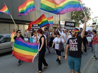 Still from the film featuring LGBTQ+ protesters holding rainbow flags marching in Cyprus.