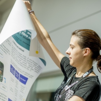 PhD student holding their research poster