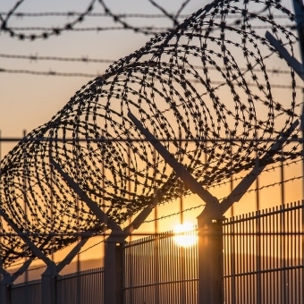 Prison barbed wiring at sunset