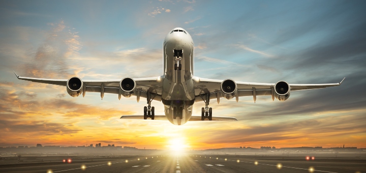 An aeroplane coming in to land with the sun shining behind it