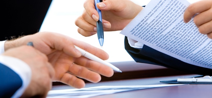 Close up of hands holding papers and pens