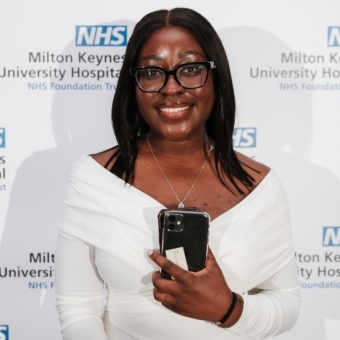 Lilly Koranteng in front of a NHS Milton Keynes University Hospitals Trust board