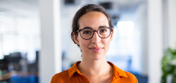 Woman in an office smiling at the camera