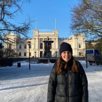 Isobel Morris standing in front of a historic building in Lund, Sweden, with snow all around