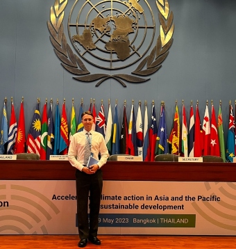 Jack-Crawford standing infront of the UN logo and a numerous country flags